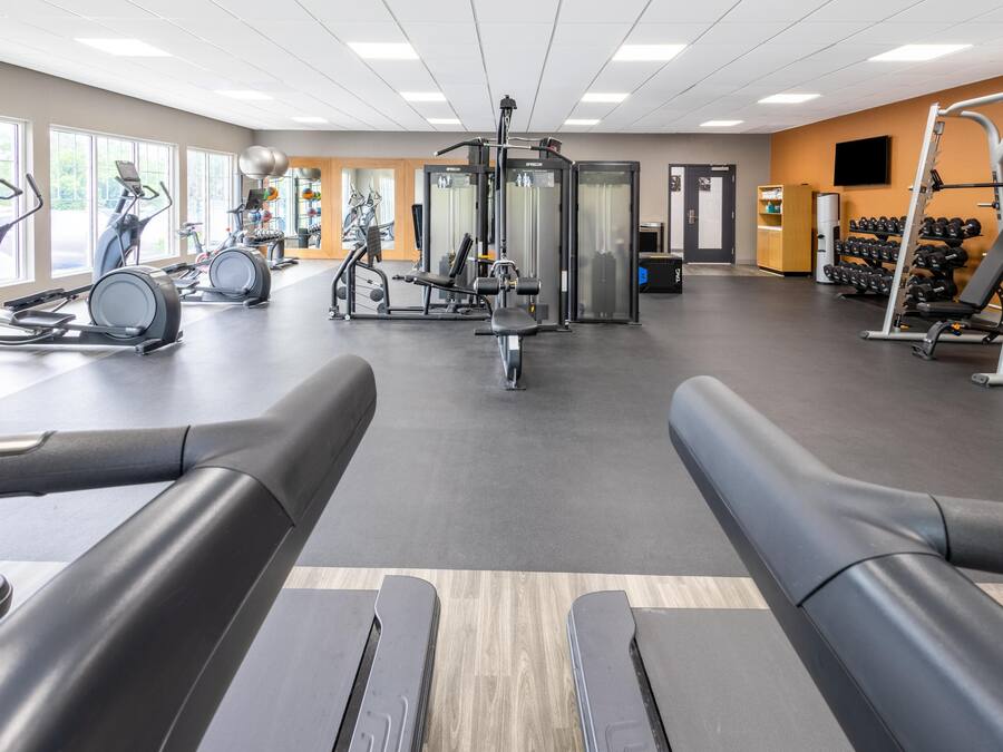 Een sportschool met loopbanden, krachttoestellen en gewichten.