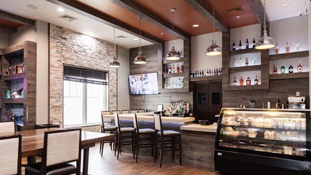 A restaurant interior with a bar area, seating, and a display case.