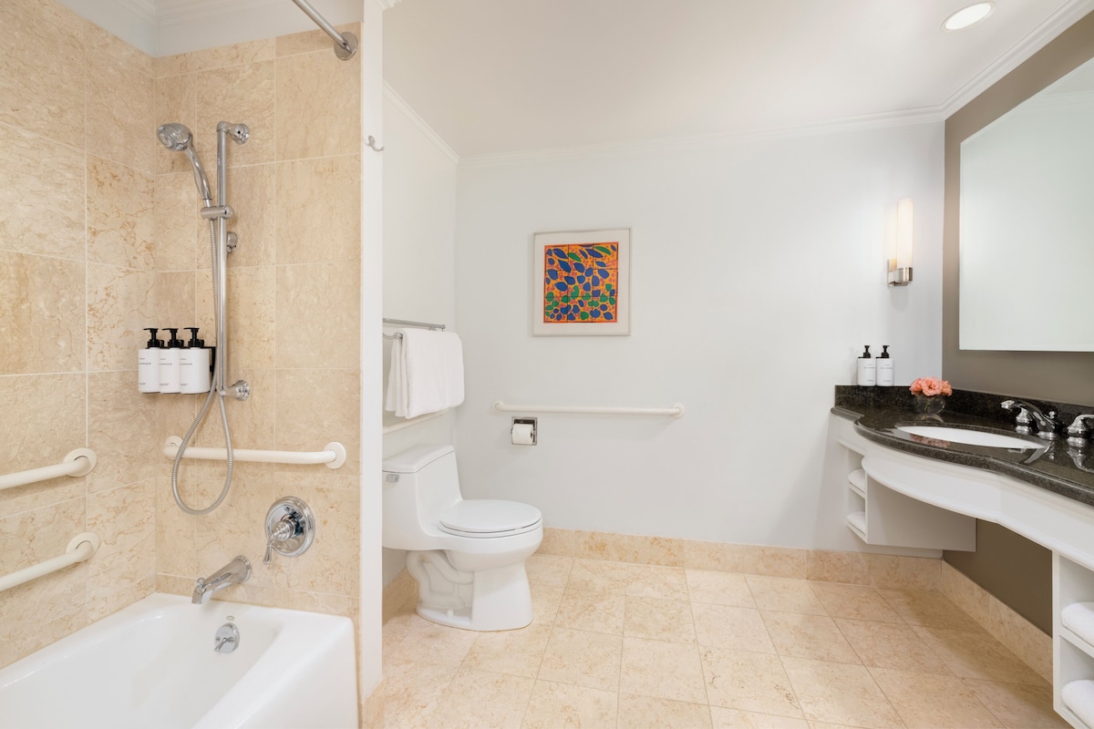A modern bathroom with a bathtub, toilet, and sink.
