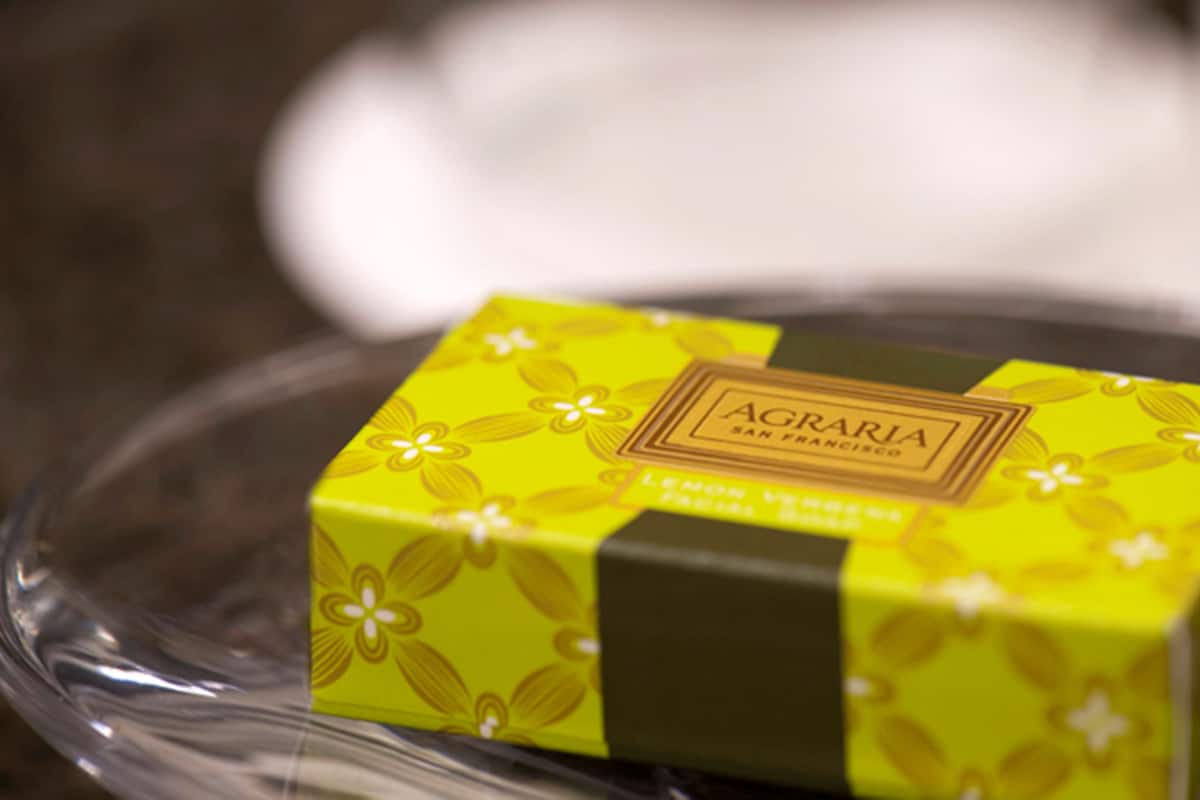 A small, yellow box with a floral pattern and the text "AGRARIA SAN FRANCISCO" on a clear, round surface.