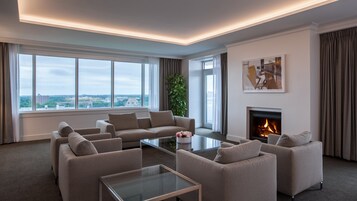 Una sala de estar moderna con chimenea, ventanas amplias y vistas a la ciudad.