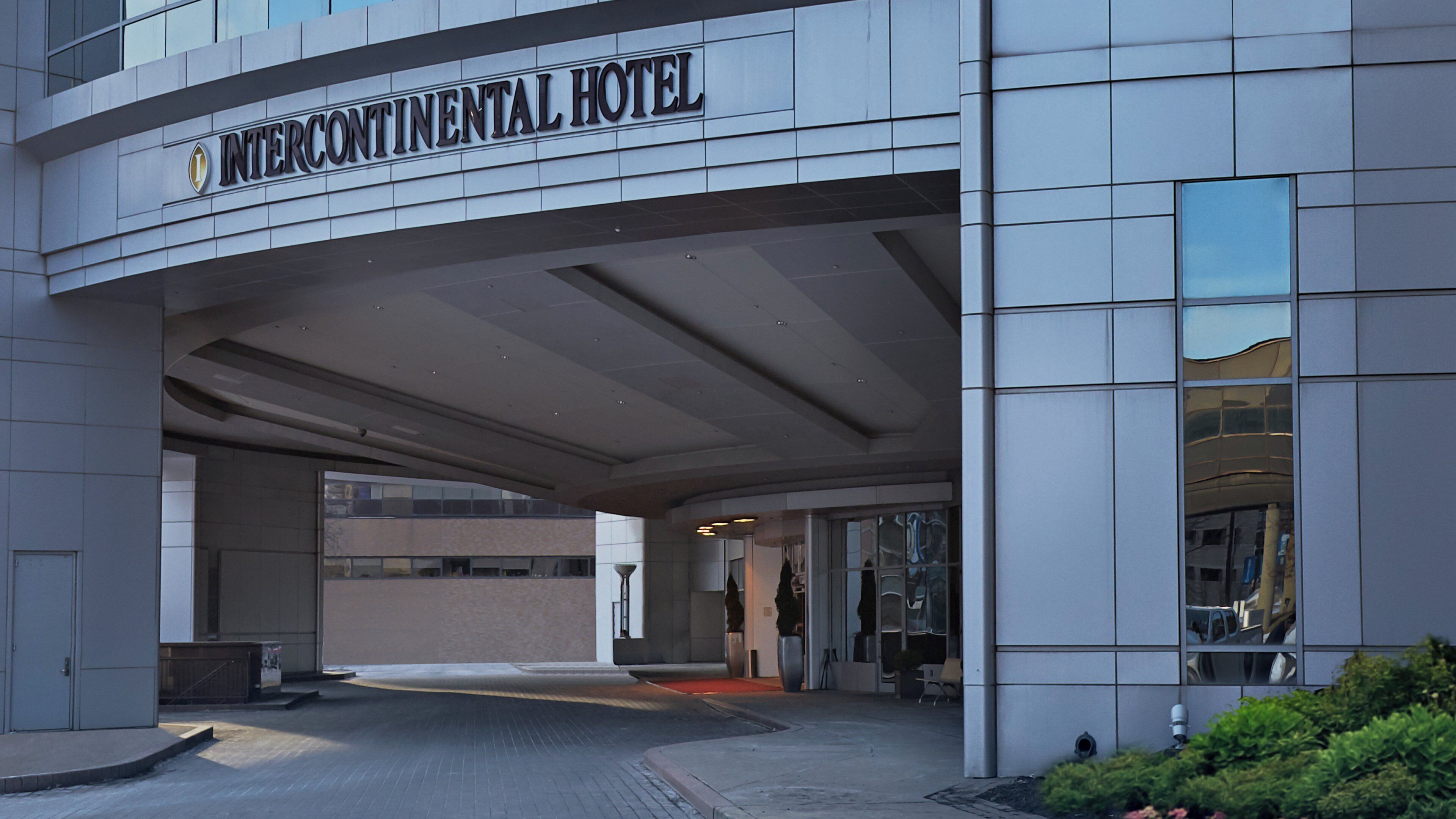 The exterior of the Intercontinental Hotel with a modern facade, large windows, and a prominent entrance.