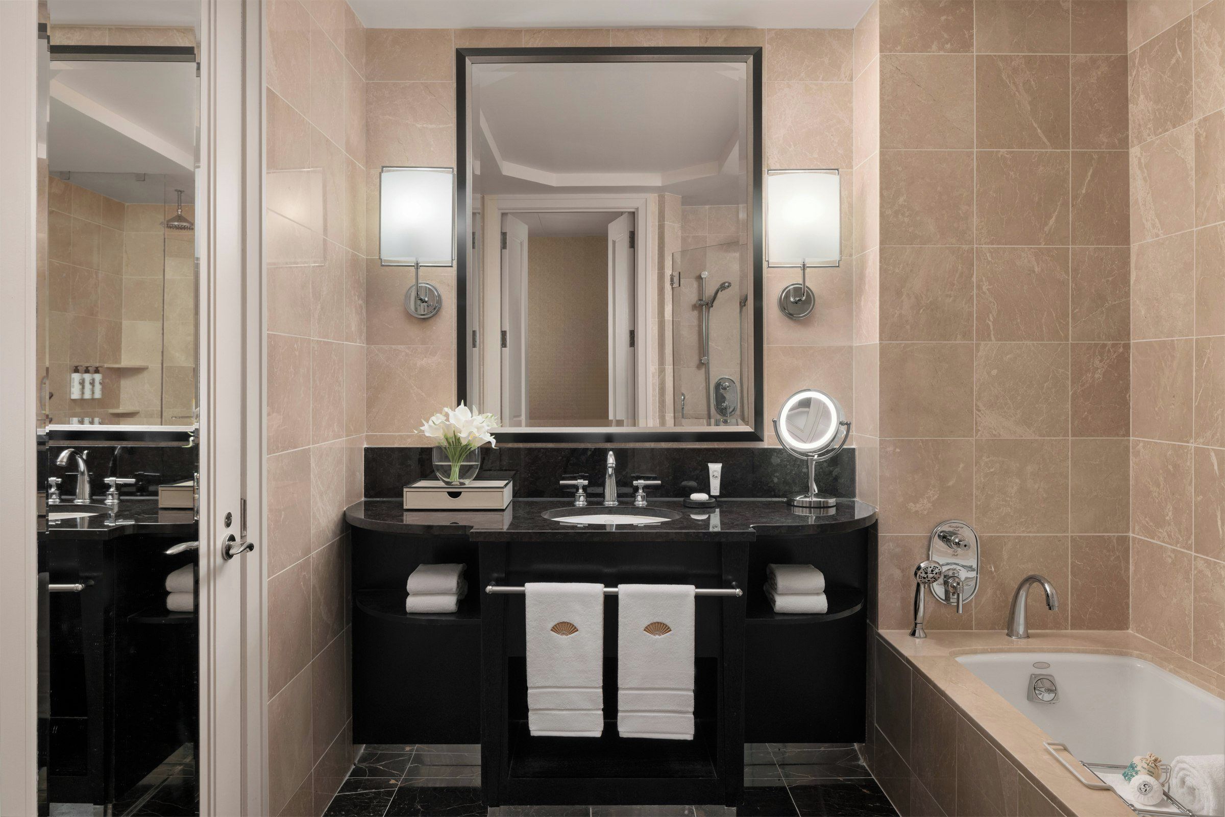 Une salle de bain moderne avec un meuble-lavabo noir, un grand miroir, une baignoire et un espace douche.
