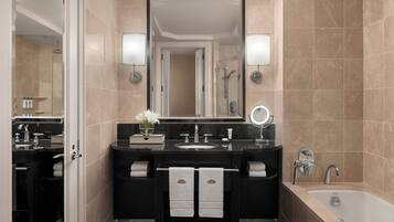 Une salle de bain moderne avec un meuble-lavabo noir, un grand miroir, une baignoire et un espace douche.