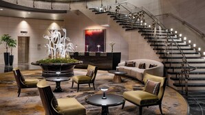 A lobby with a central seating area, a staircase, and a reception desk. - Mandarin Oriental, New York (New York)