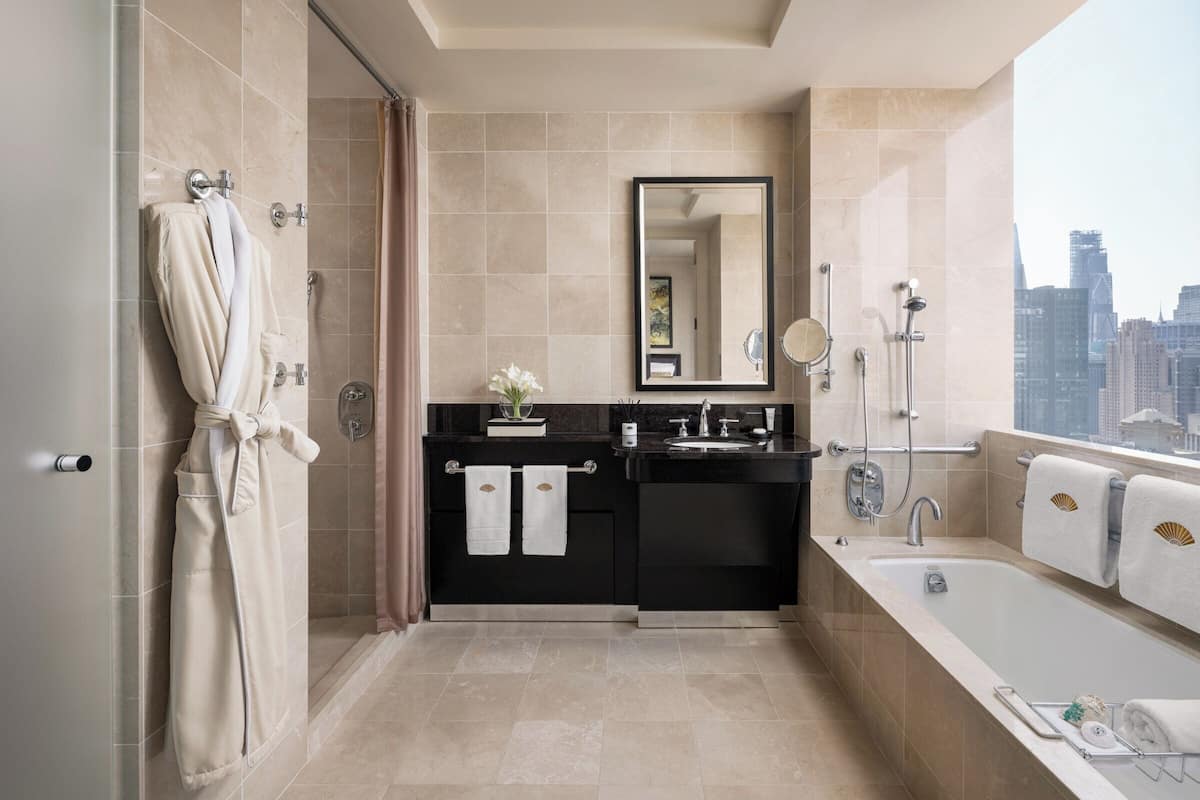 A modern bathroom with a walk-in shower, a bathtub, and a vanity with a mirror.