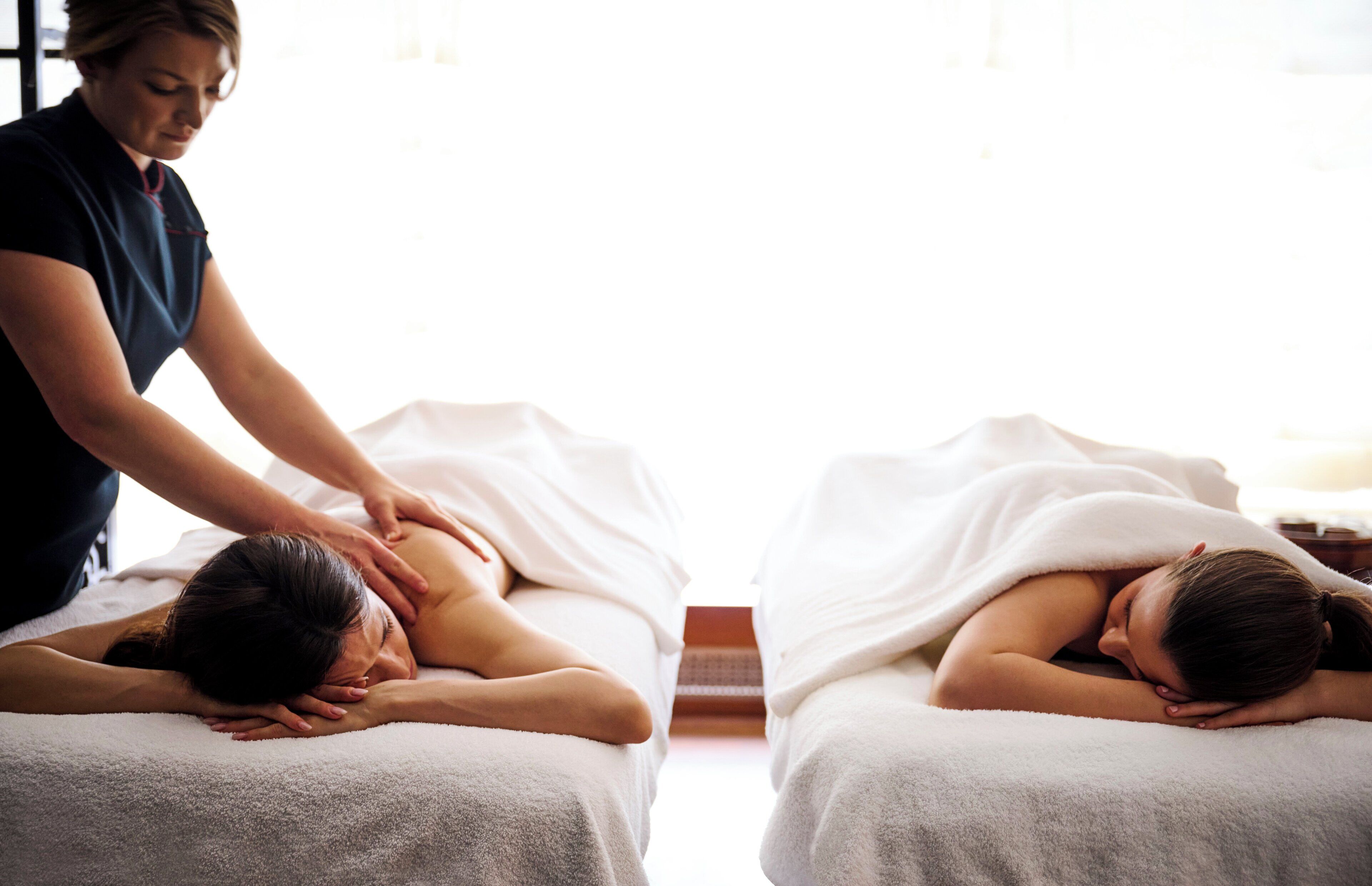 A massage therapy room with two clients receiving treatment.