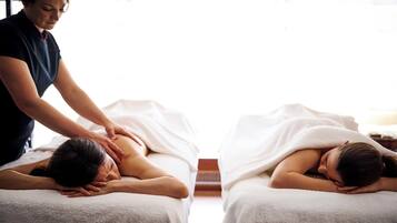 A massage therapy room with two clients receiving treatment.