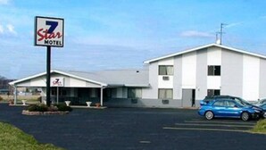 Un motel de 7 estrellas con un edificio sencillo de dos pisos y un estacionamiento.