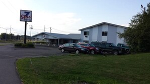 Un motel de 7 estrellas con aparcamiento y varios coches estacionados.