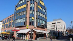 A hotel with a modern architectural design, featuring multiple floors and large windows.