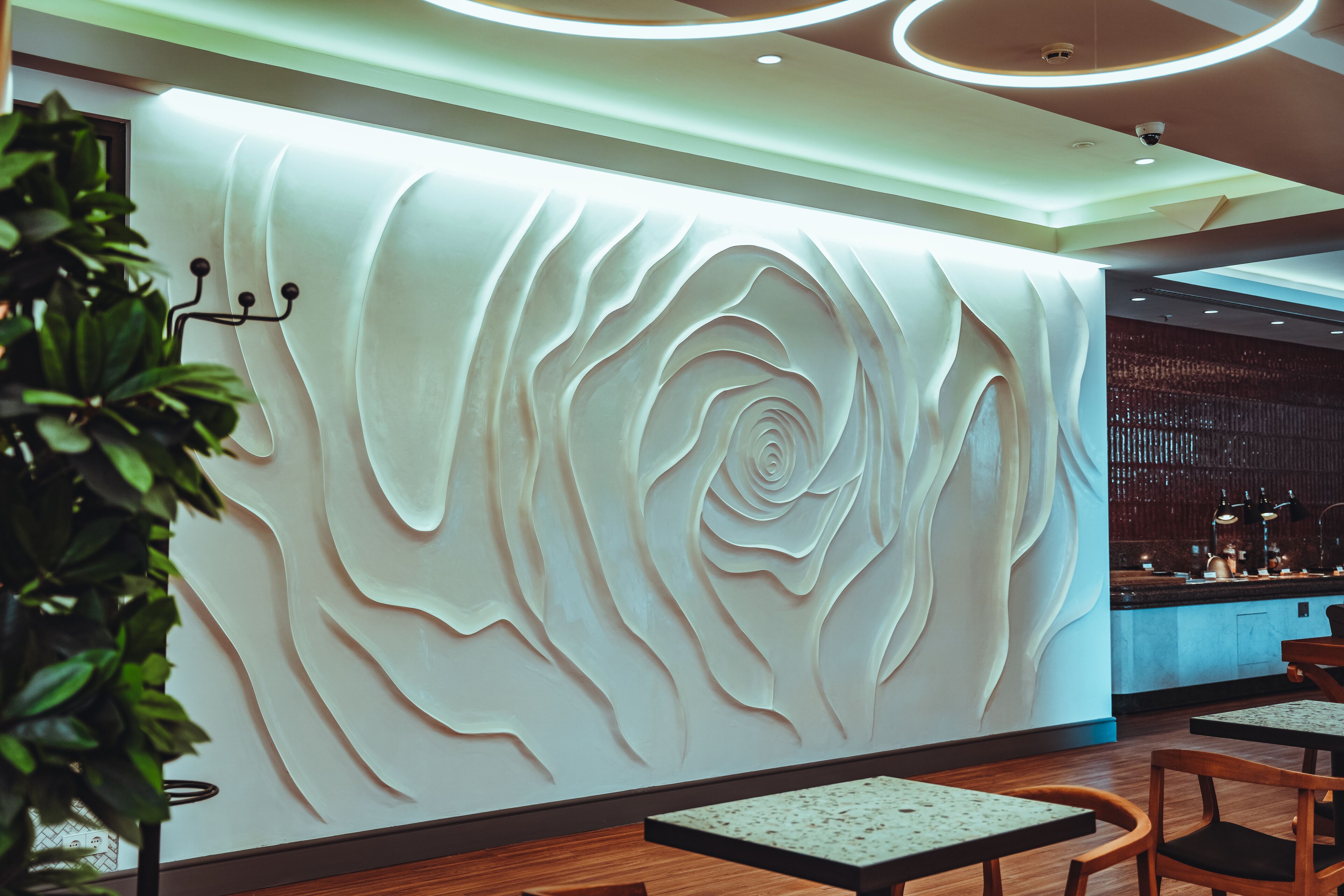 Un interior moderno con diseño de pared texturizado, suelo de madera y una zona de bar.