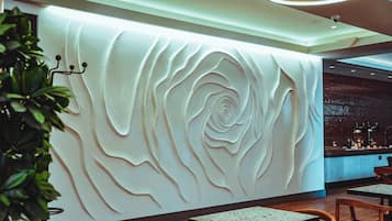 Un interior moderno con diseño de pared texturizado, suelo de madera y una zona de bar.