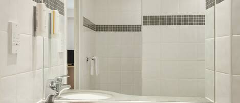 A modern bathroom with two sinks, a mirror, and a shower area.