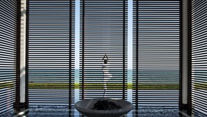 A modern interior with a stone basin in the center, surrounded by black and white striped walls.
