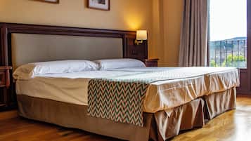 Ein Hotelzimmer mit einem großen Bett, einem Holz-Kopfteil und Blick ins Freie.