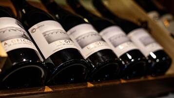 A row of wine bottles with labels, arranged on a wooden surface.