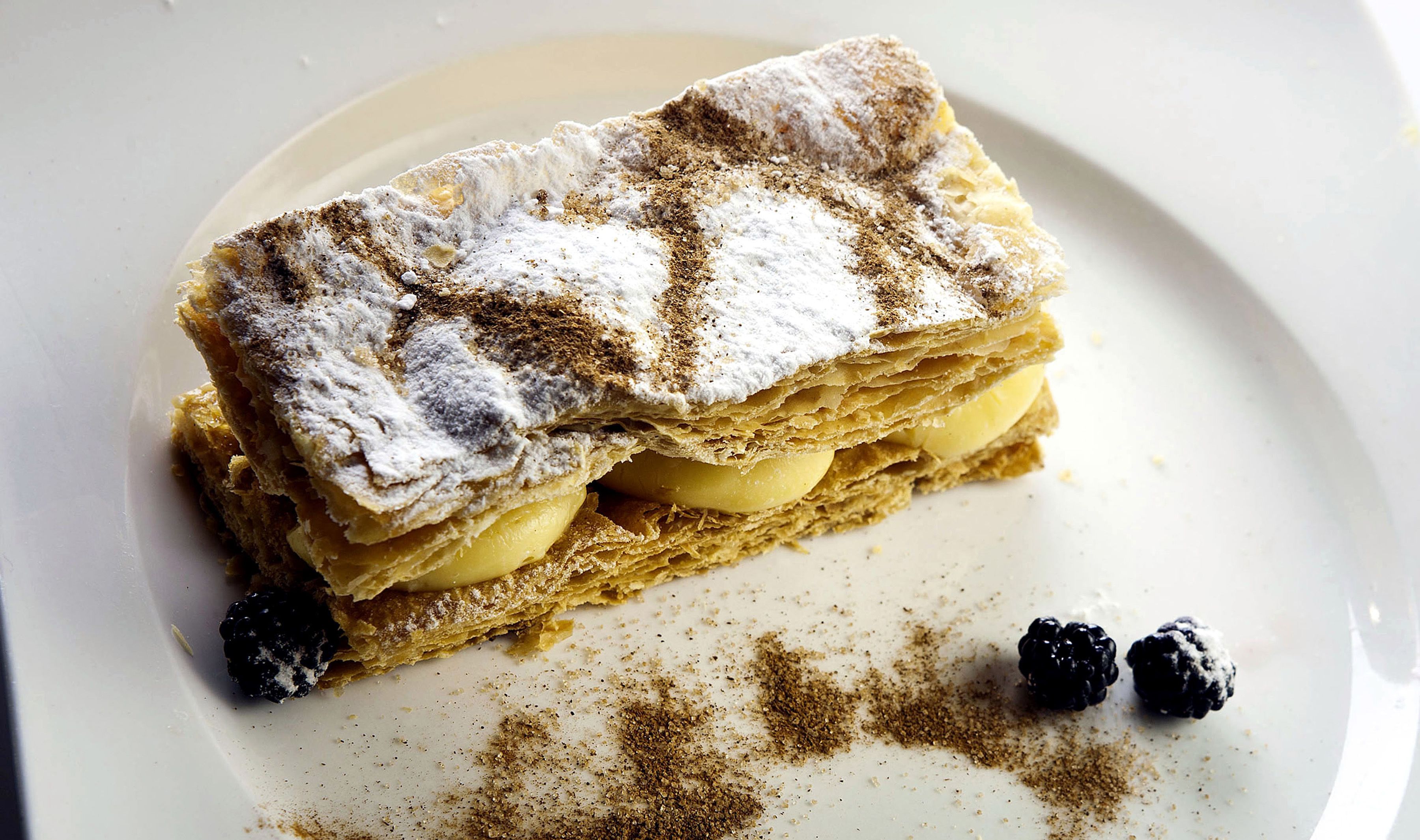 Un postre con capas y azúcar glas sobre un plato.