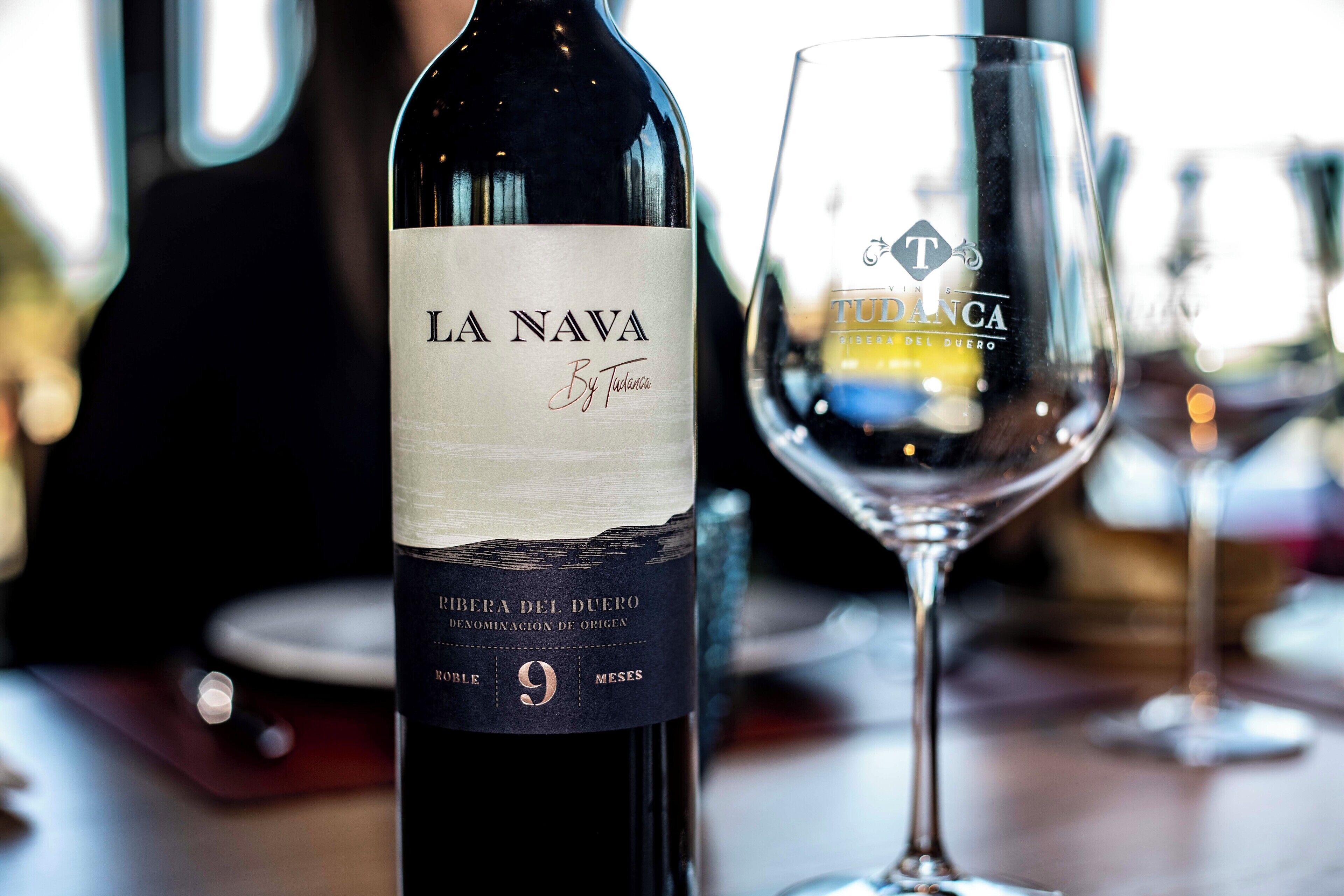 A bottle of La Nava wine with a label and a glass.