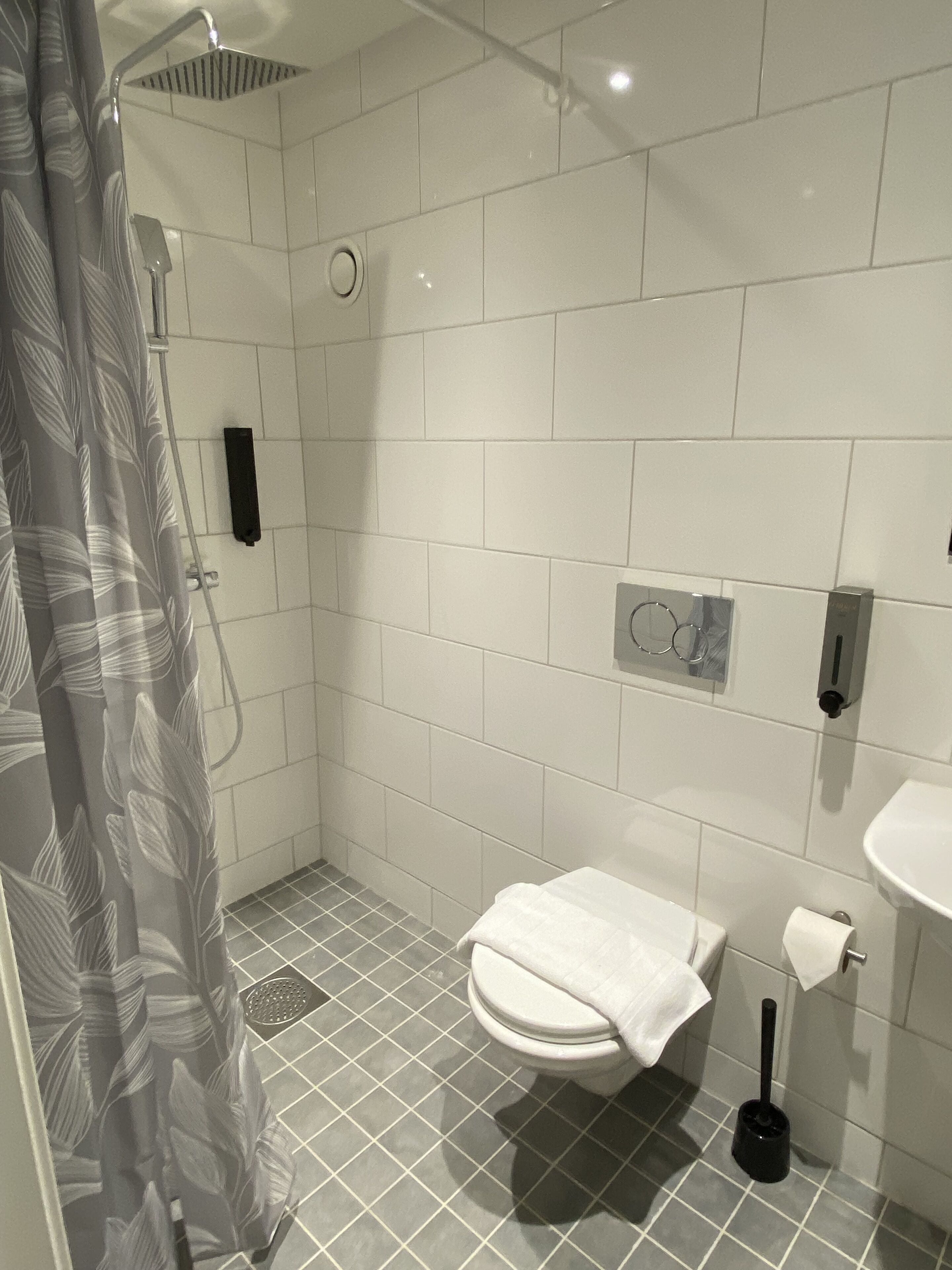 A bathroom with a shower, toilet, and sink.