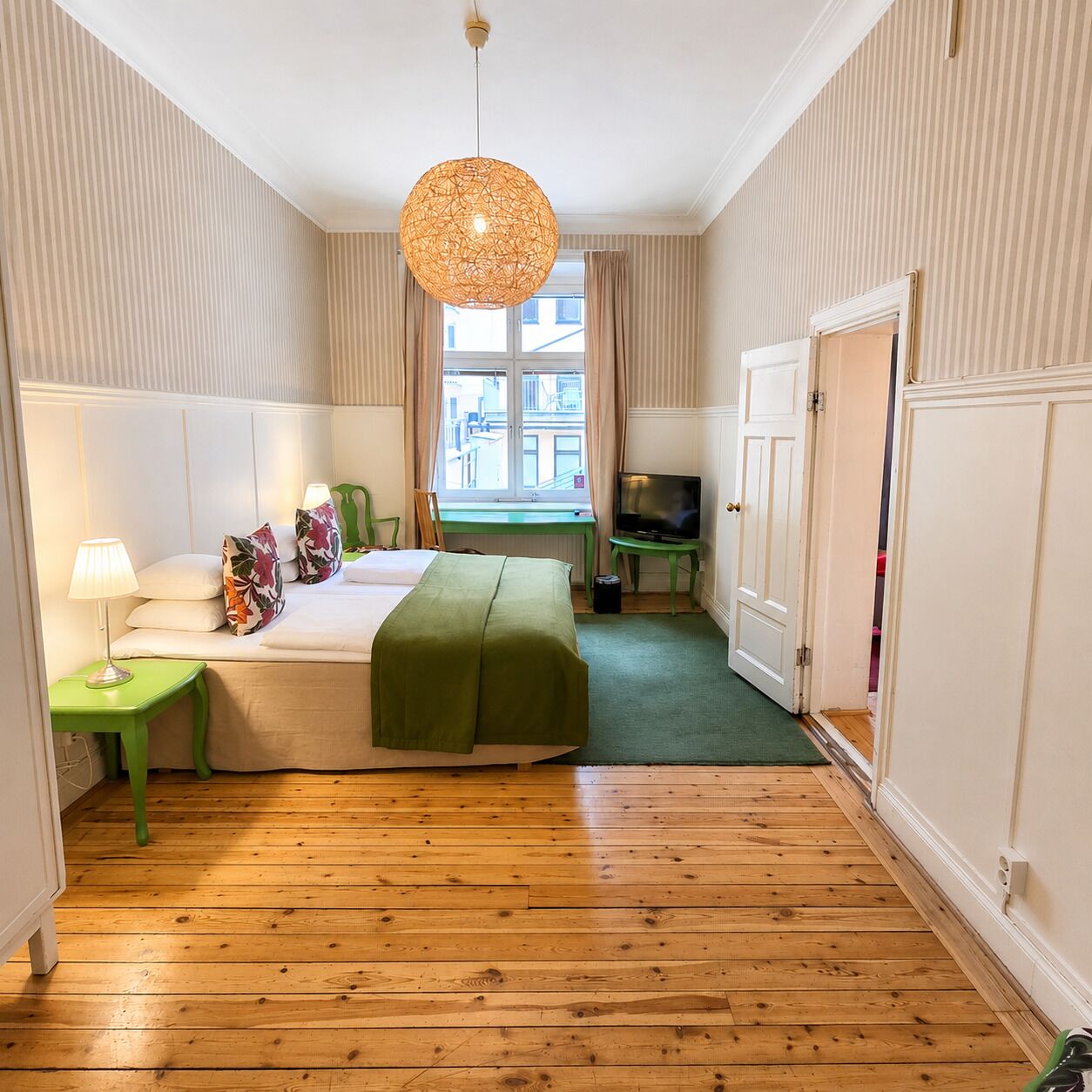 Une chambre d’hôtel avec un lit, un bureau, une télévision et une fenêtre.