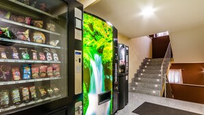 A vending machine with snacks and a digital display of a waterfall. - JCH Congreso (Salamanca)