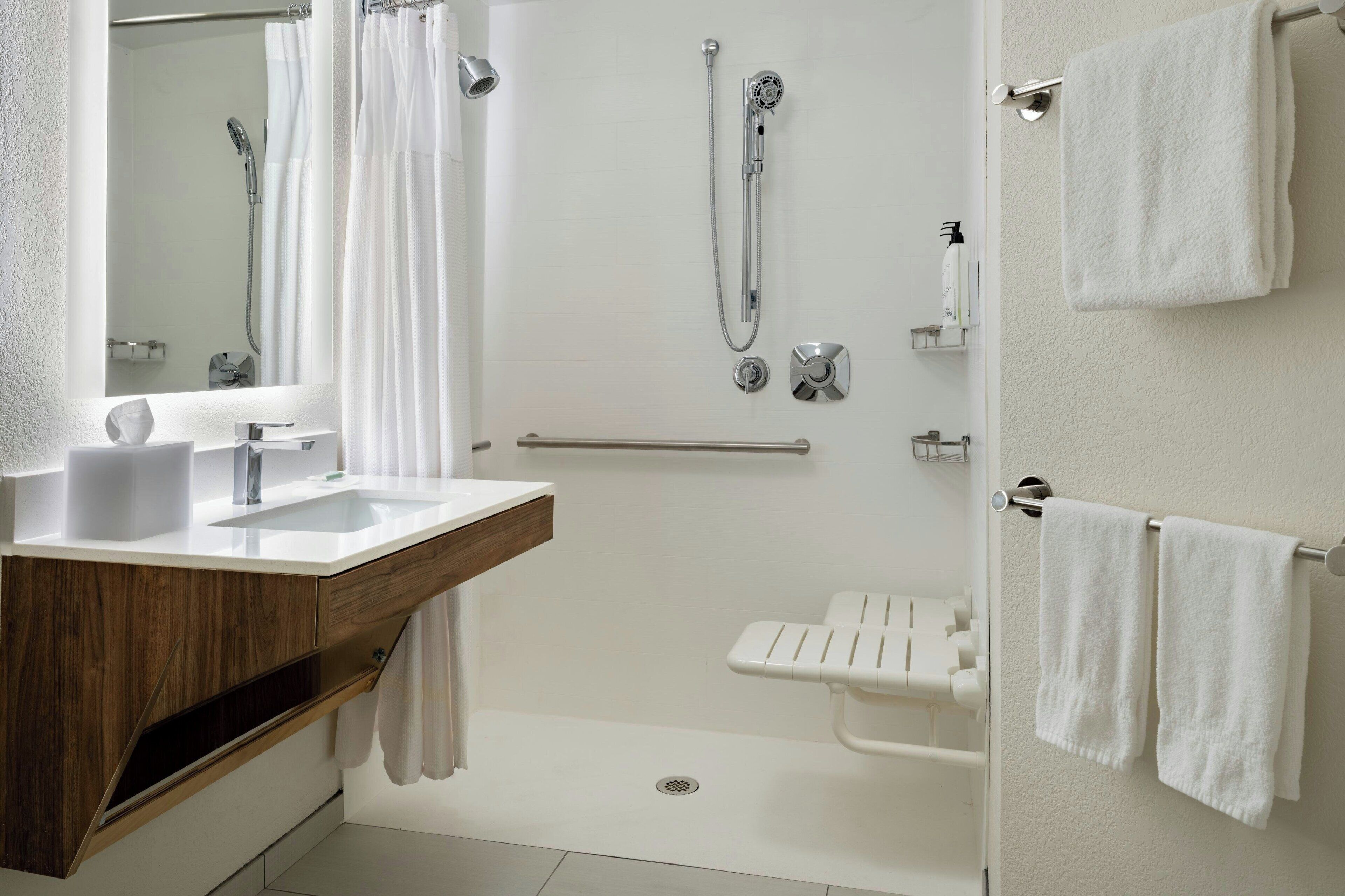 A modern bathroom with a shower, a sink, and a toilet.