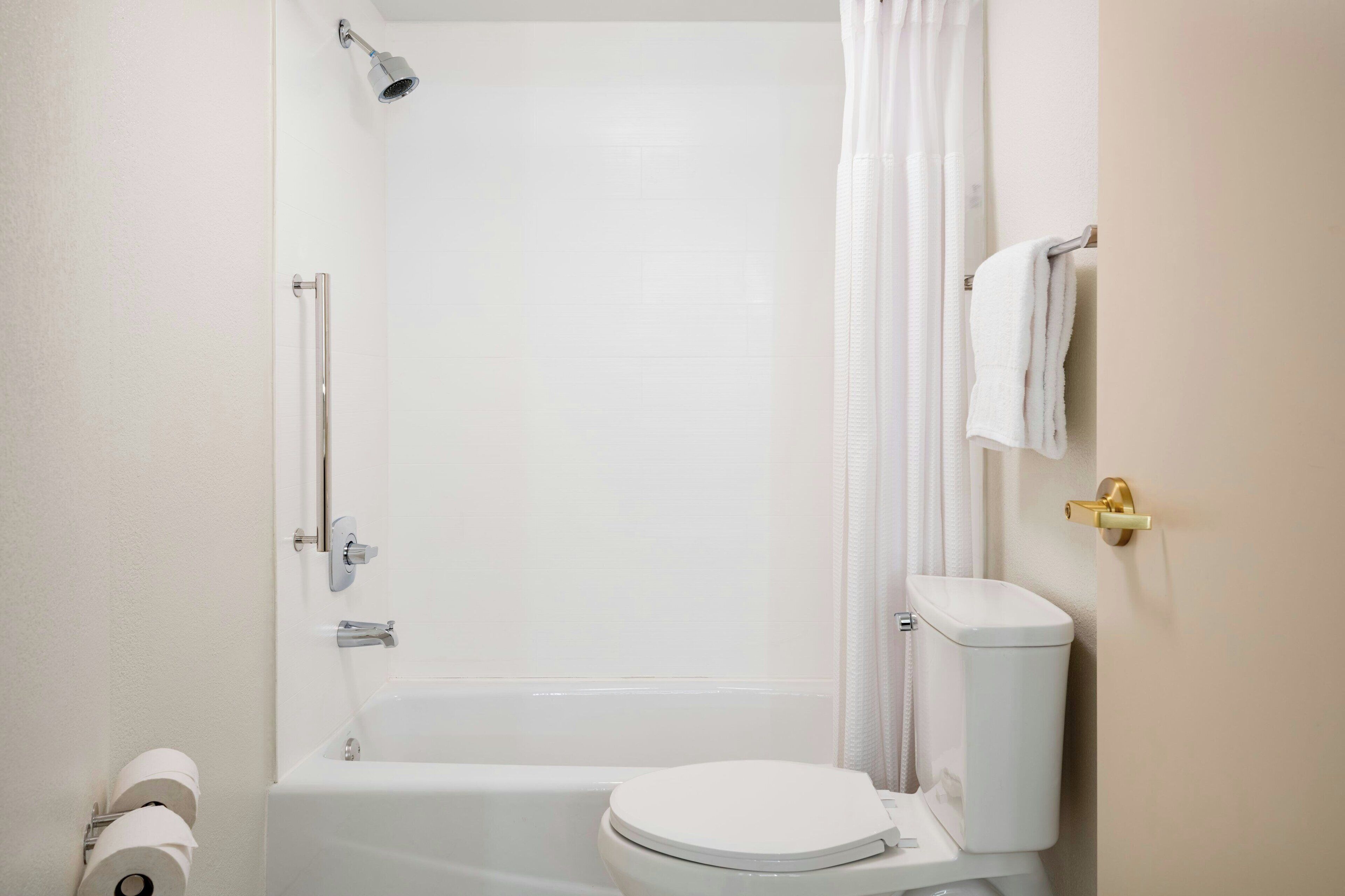A bathroom with a bathtub, toilet, and shower.