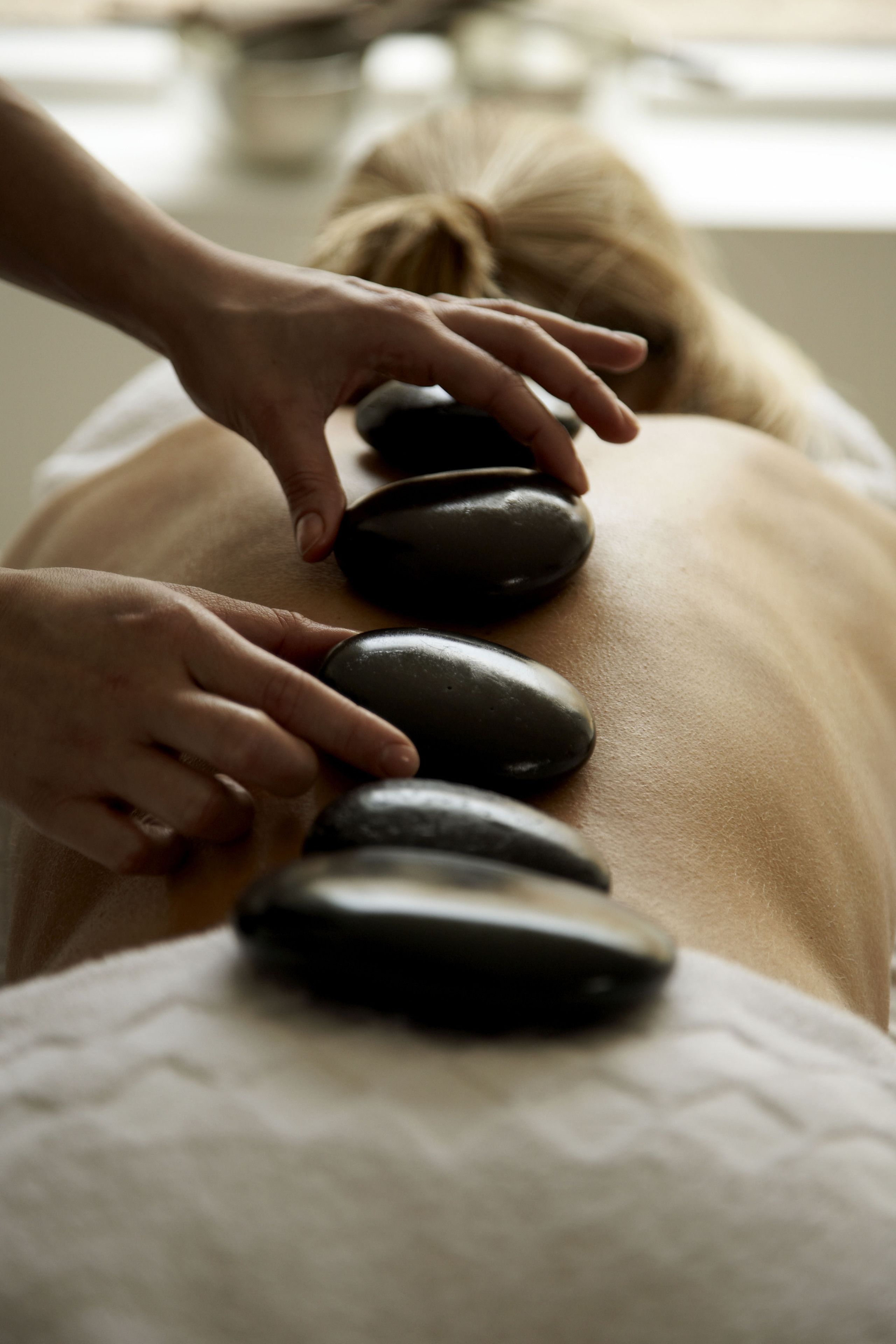 A person receiving a stone massage.