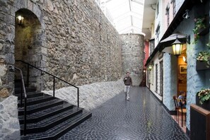 A narrow stone corridor with a staircase leading to a higher level. - Travelodge Galway (Galway)