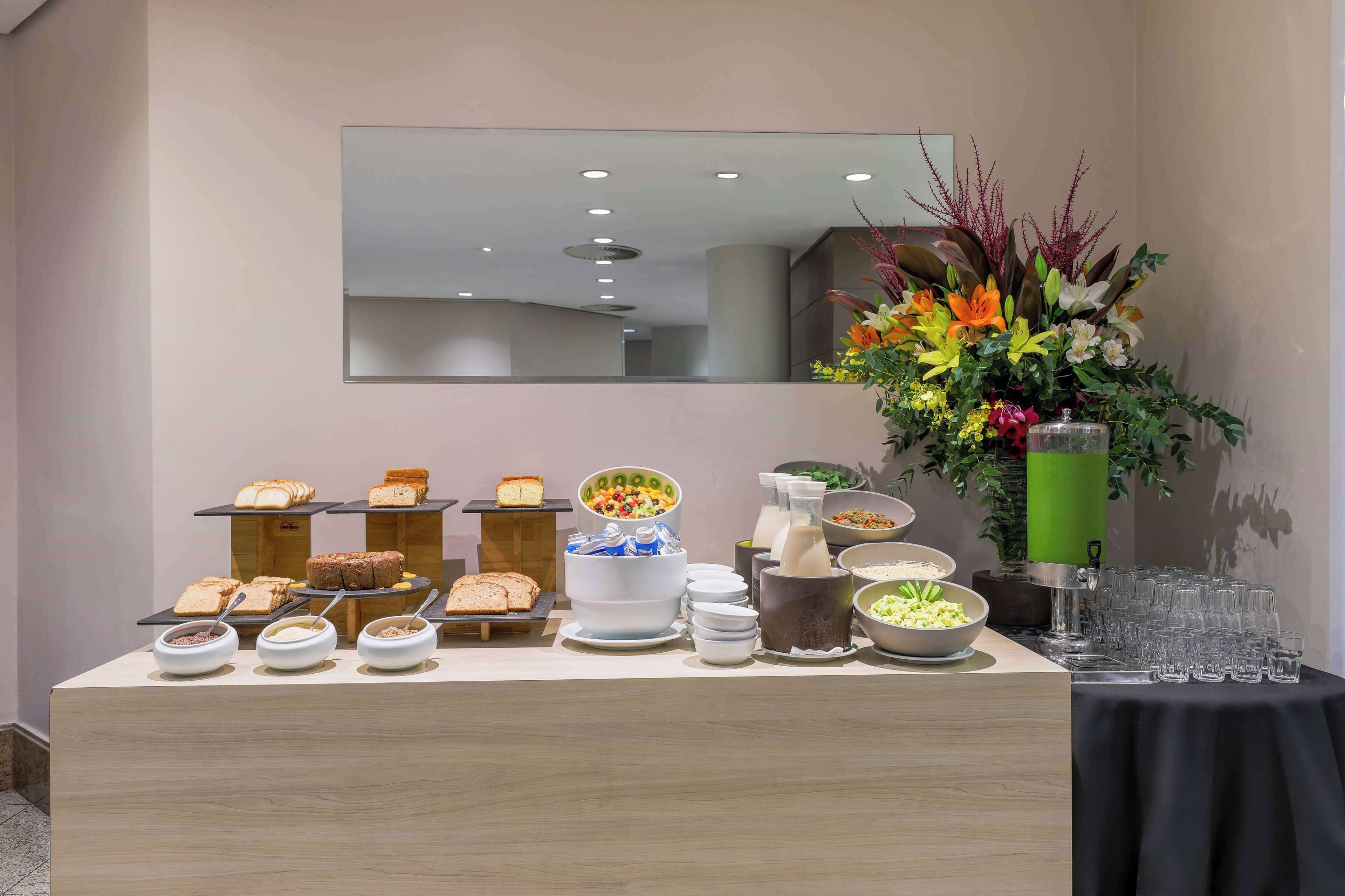 A buffet setup with various food items and a large floral arrangement.