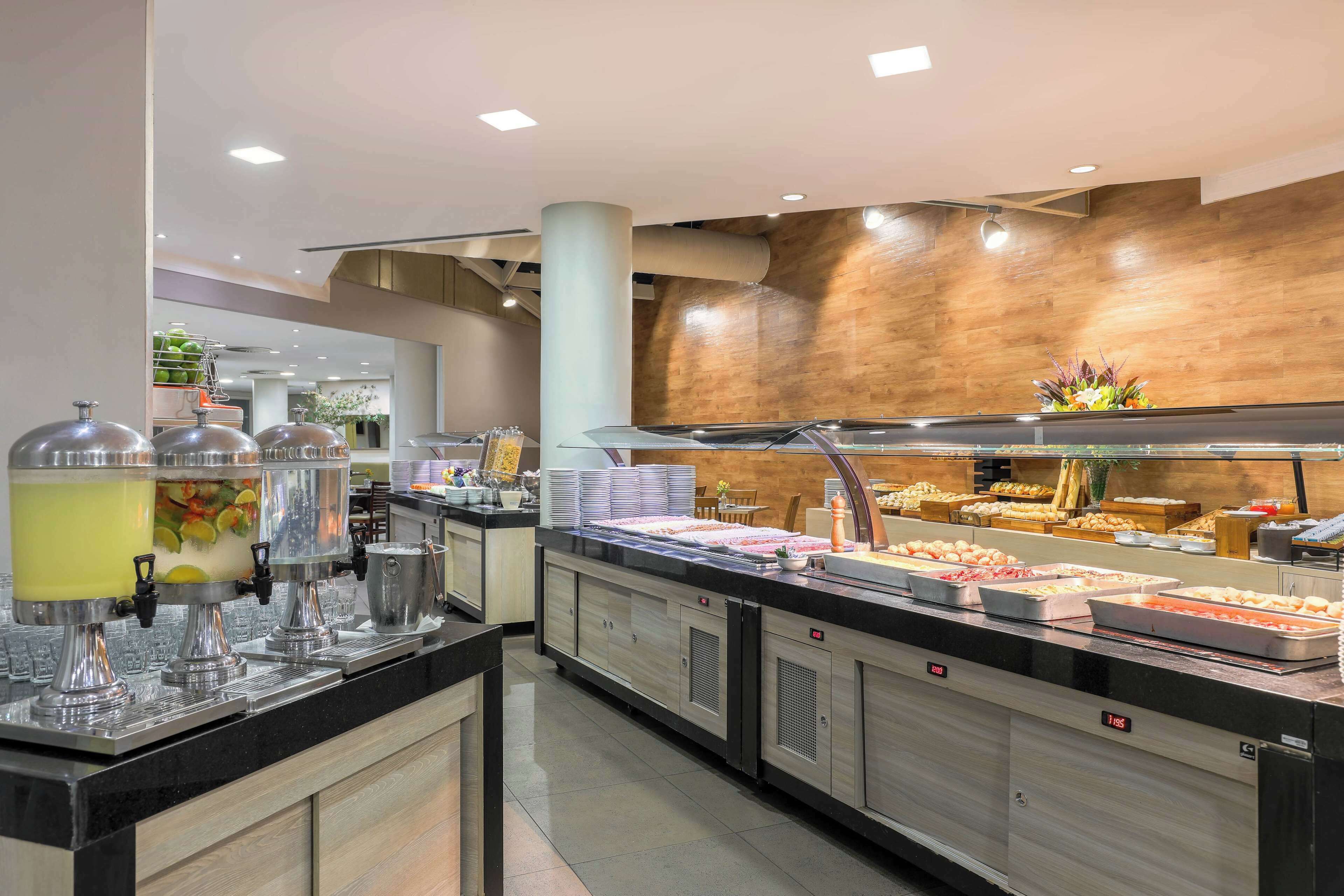Montaje de bufé con diferentes estaciones de comida y un diseño interior moderno.