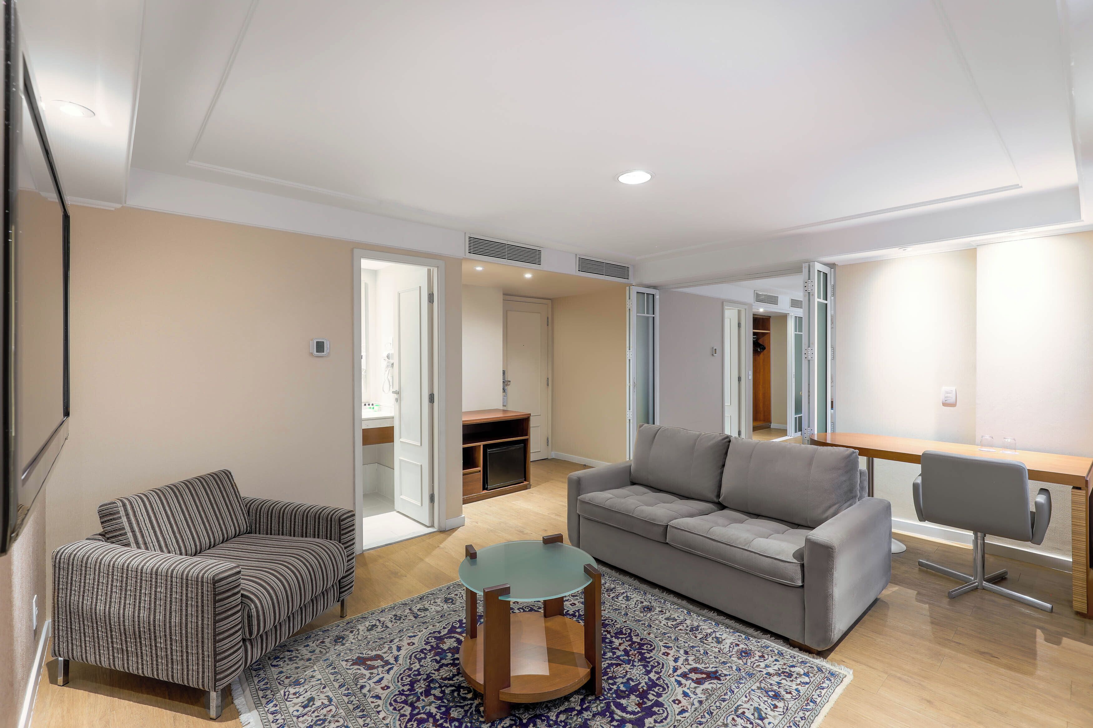 Uma sala de estar moderna com um sofá, uma mesa de centro e uma escrivaninha.