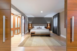 Una camera da letto moderna con un letto grande, una testata in legno e lampade da comodino.