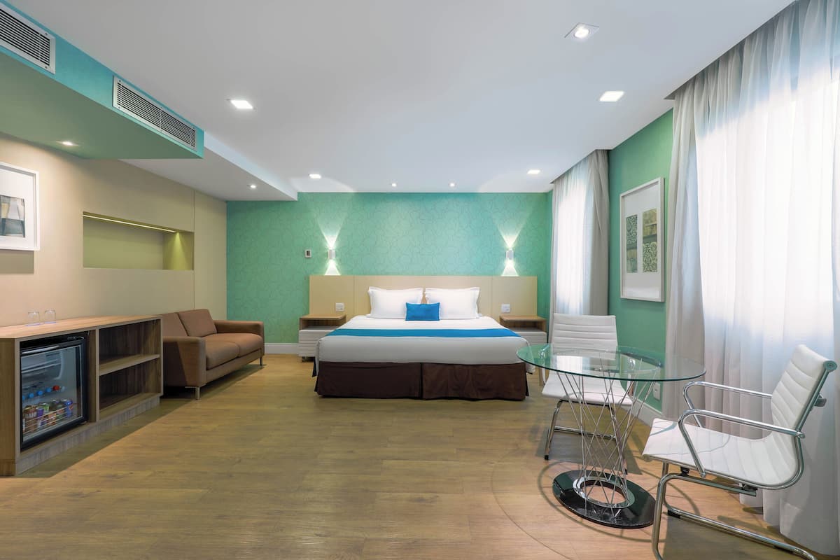 Suite Deluxe | Hypo-allergenic bedding, minibar, in-room safe, laptop workspace