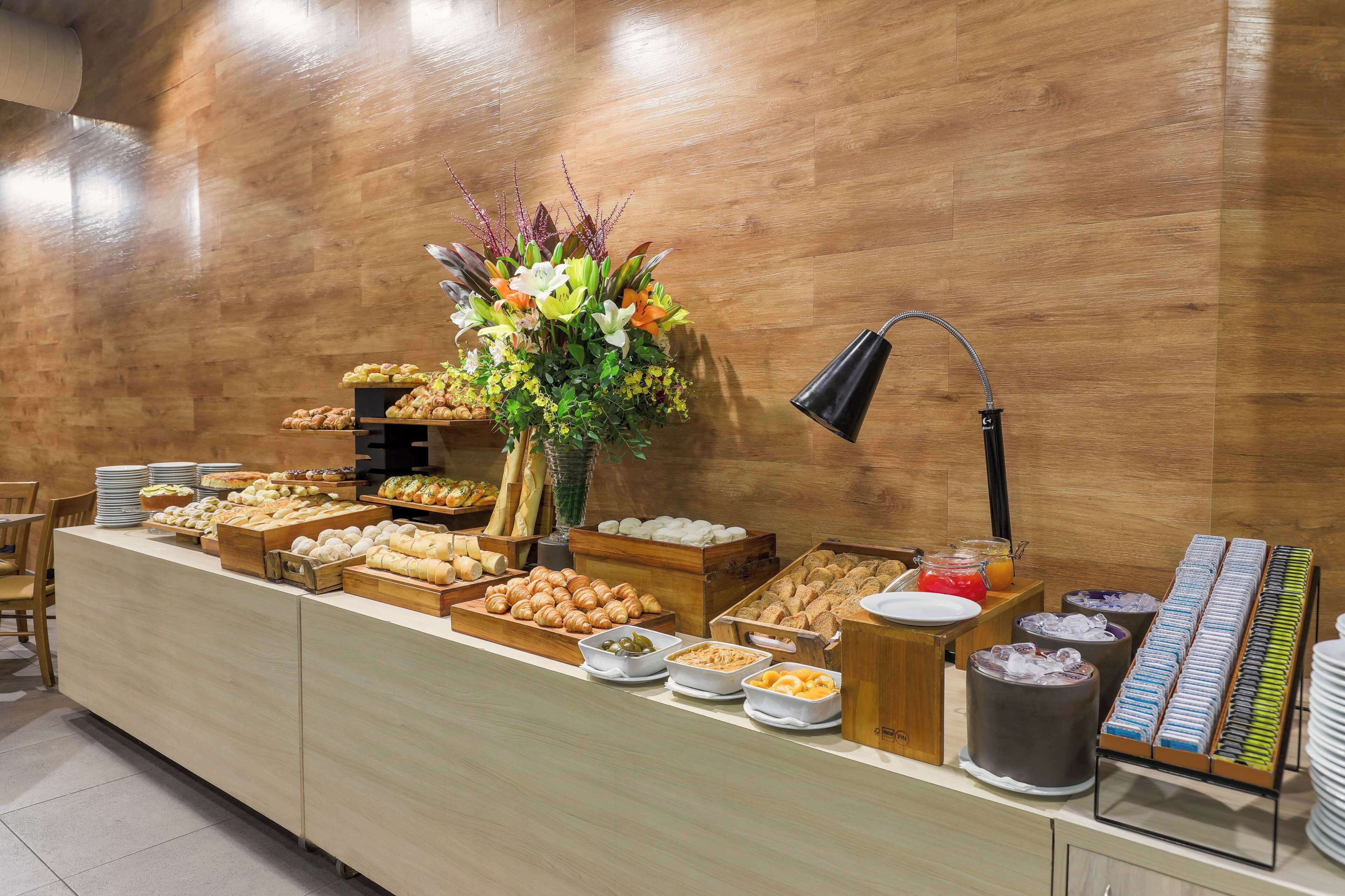 A buffet setup with various food items and a floral centerpiece.