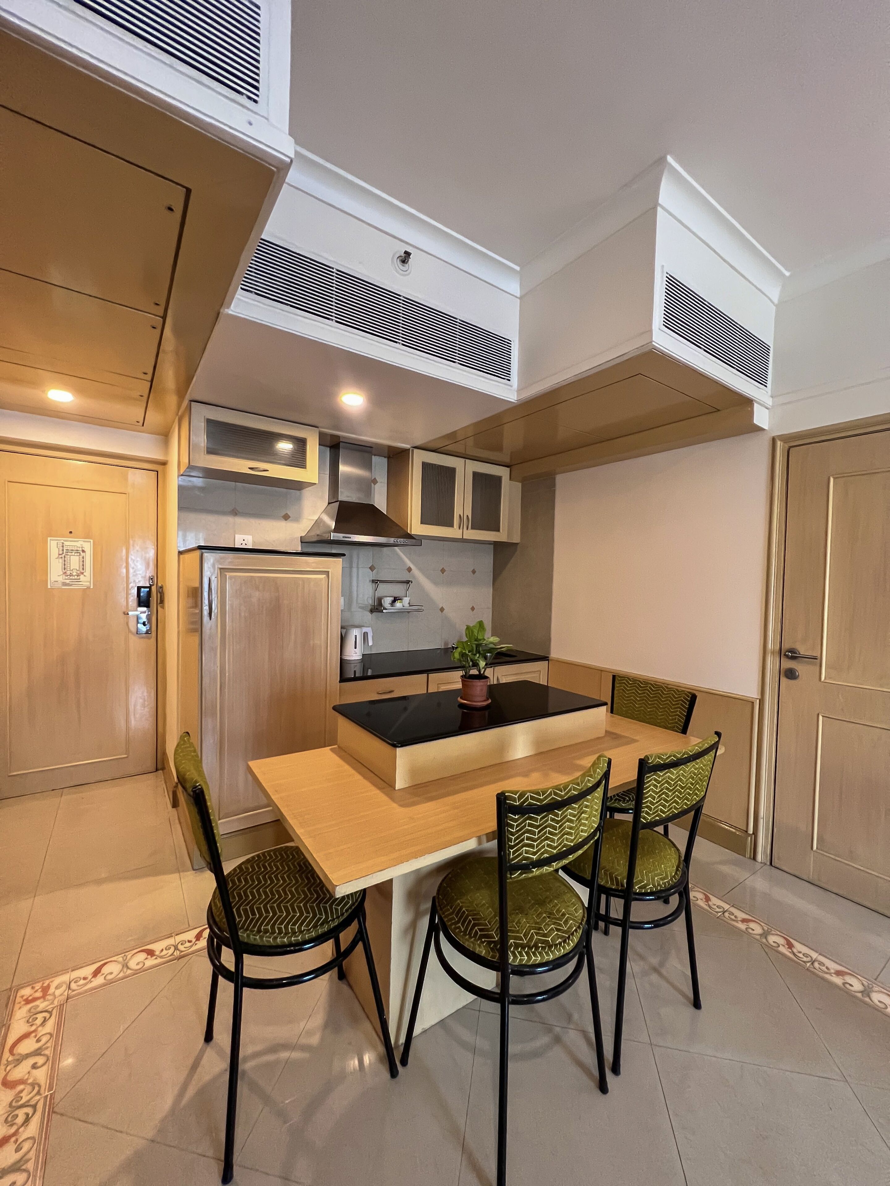 A compact kitchen with a central island, four chairs, and a dining table.