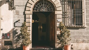 Una entrada en arc a un edifici amb un rètol que diu 'Domus Florentiae Hotel'.