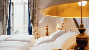A hotel room with a bed, a lamp, and curtains.