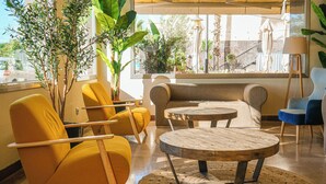 Un área de estar moderna con sillas amarillas, un sofá y una mesa de centro de madera.