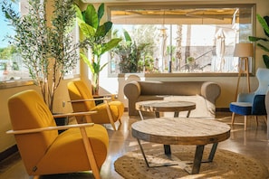 A modern lounge area with yellow chairs, a sofa, and a wooden coffee table. - htop Pineda Palace & SPA - Adults Only (Pineda de Mar)