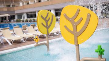 Un área de piscina con sillas de descanso y una fuente de agua.