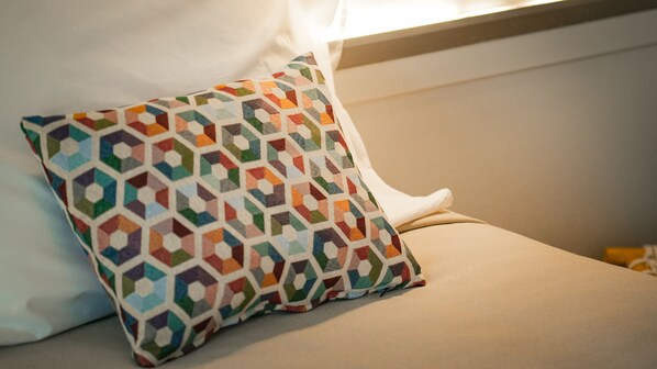 A pillow with a geometric pattern on a bed.
