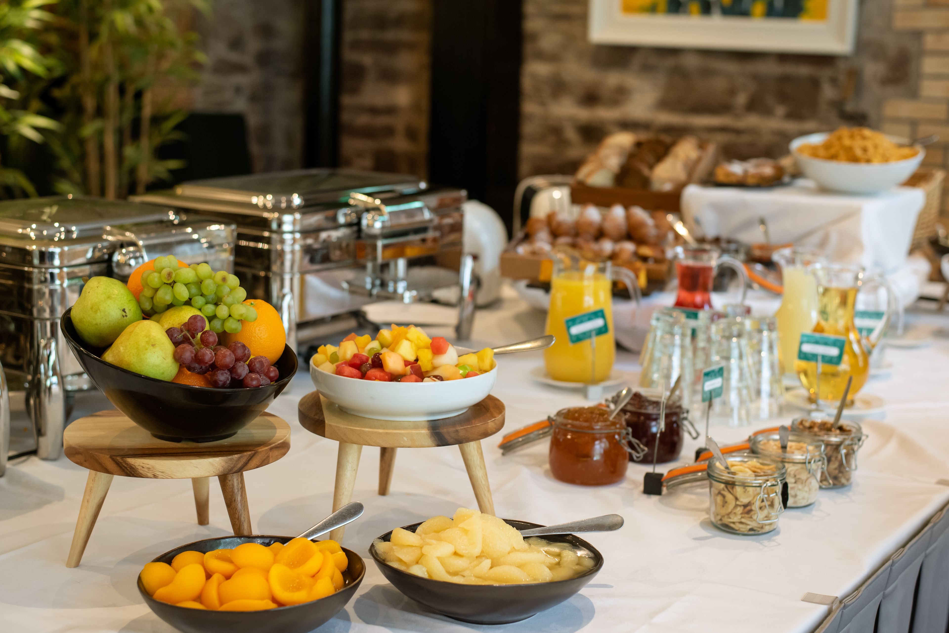 Un buffet proposant une variété de fruits, de jus et d’aliments pour le petit-déjeuner.