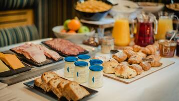 Un bufé de desayuno con diversas opciones de comida y bebidas.