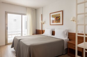 A hotel room with a double bed, a wooden nightstand, a framed picture on the wall, and a sliding door leading to a balcony. - htop Royal Star & SPA (Lloret de Mar)