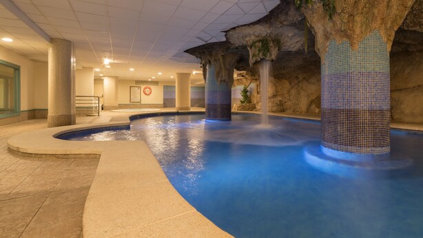 Una piscina interior con un telón de fondo de formaciones rocosas únicas y pilares azulejados.