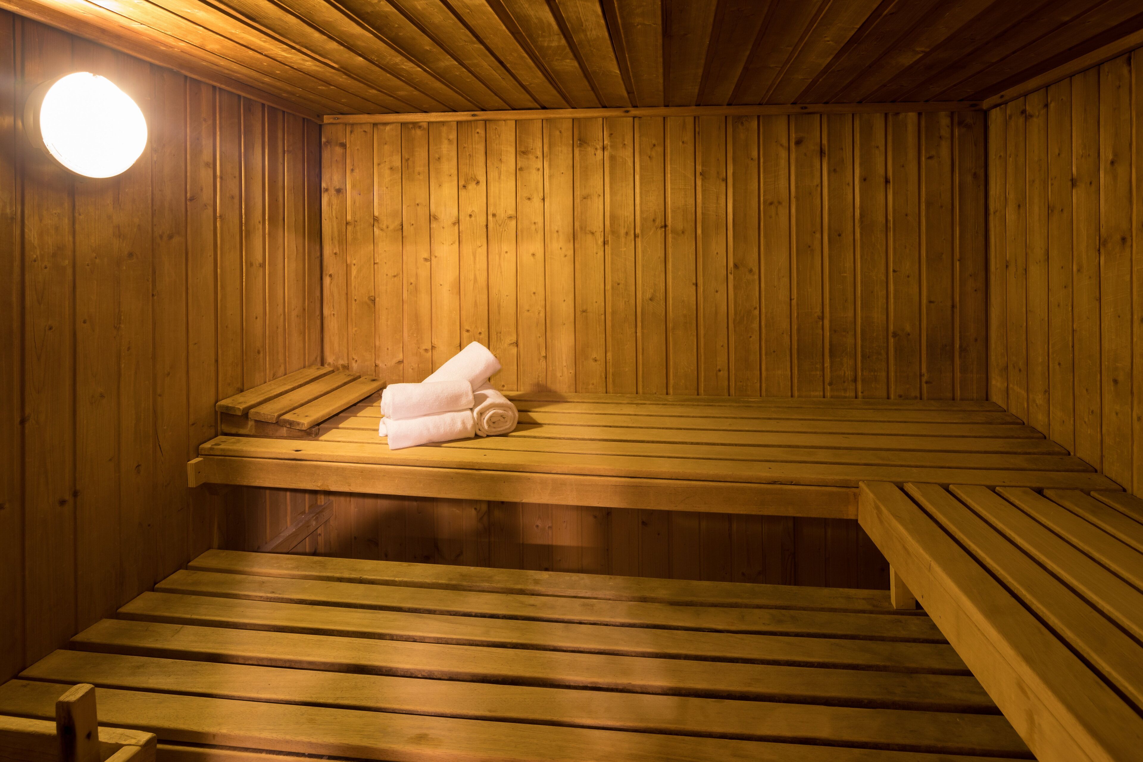 Una sauna de madera con bancos y un asiento de banco.