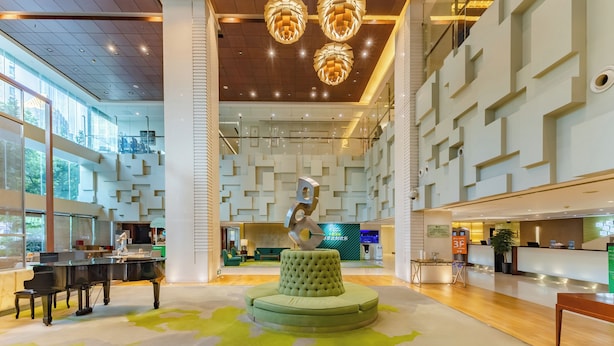A spacious lobby with a central seating area, a reception desk, and a modern staircase. - Holiday Inn Vista Shanghai by IHG (Shanghai)