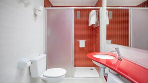 A bathroom with a white toilet, a red sink, and a glass-enclosed shower. - Hotel Servigroup Venus (Benidorm)
